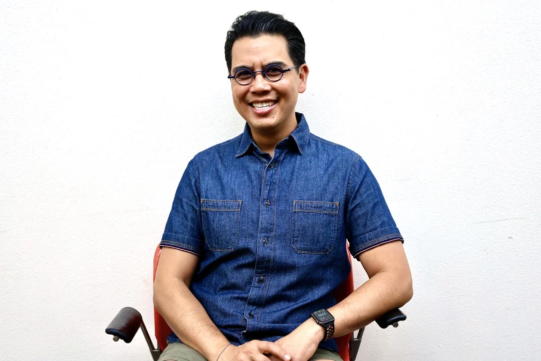 Smiling man in a blue denim shirt, studio portrait