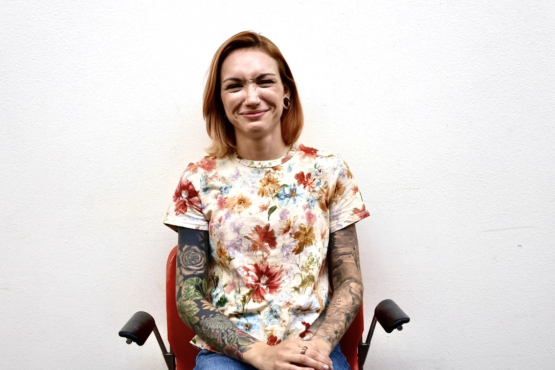 Woman with auburn hair and a floral top, studio portrait