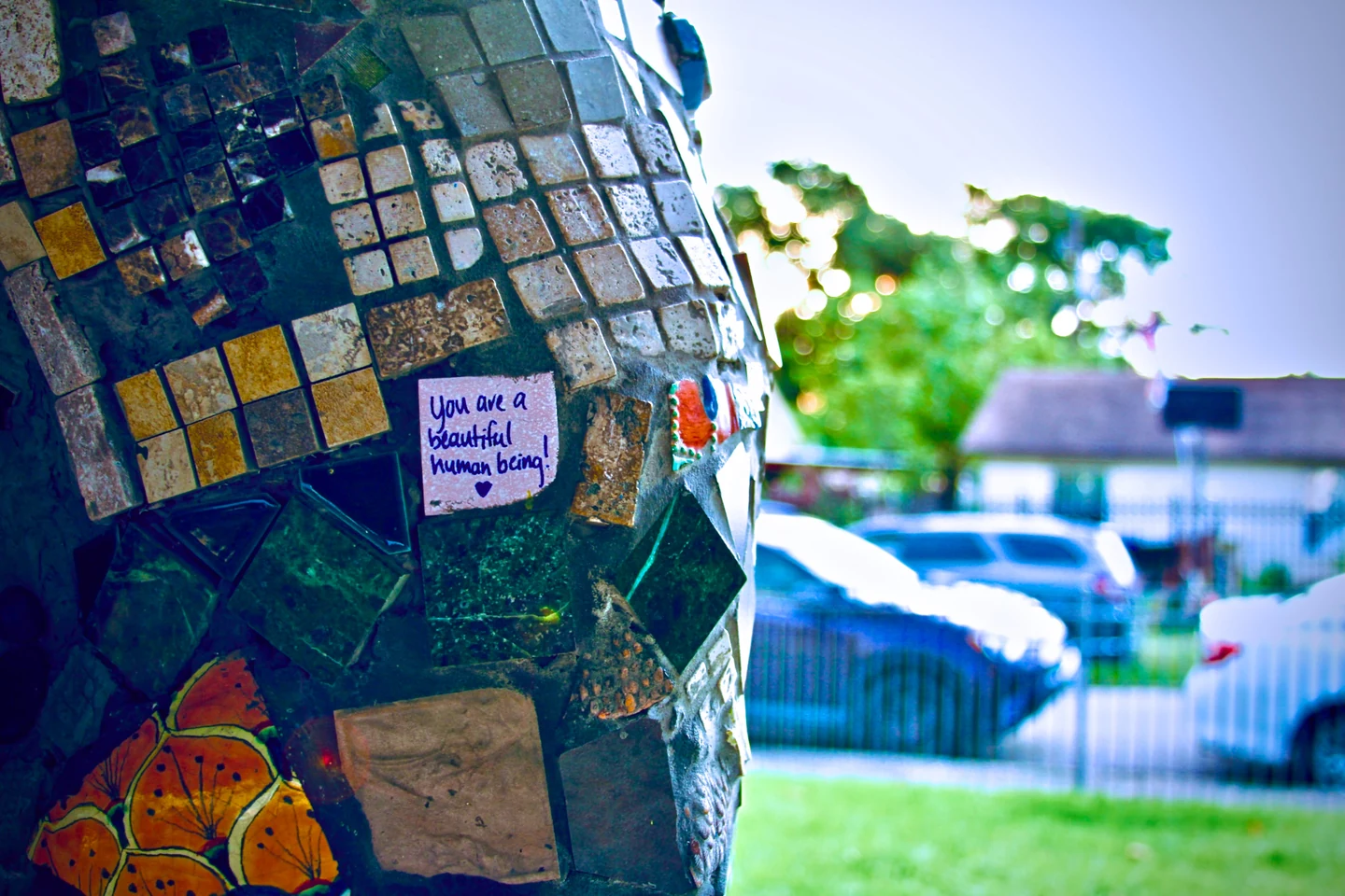 Mosaic artwork detail with a handwritten note reading "you are a beautiful human being"