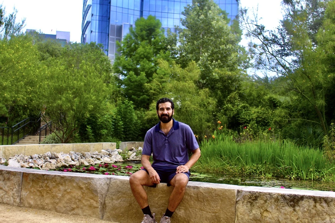 Man seated in a garden courtyard, environmental portrait
